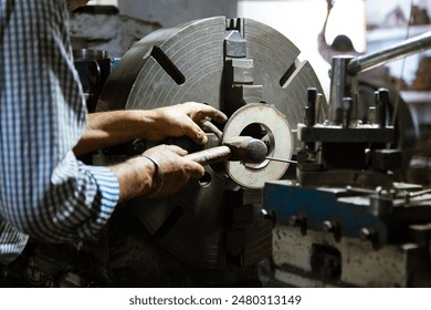 Old Man Operating Vintage Lathe Machine in Original Factory, Top-Lit, Demonstrating Precision Craftsmanship.