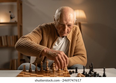 Old man playing chess lonely at table in the evening at home. Copy space - Powered by Shutterstock