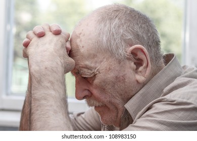 Old Man Praying At Home Near The Window