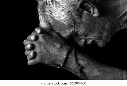 Old Man Praying With A Rosary In His Hands