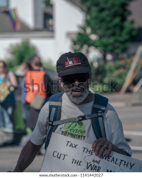 a old man at a protest in Olympia Washington on\
July 19th 2018.