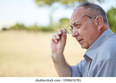 Old Man Putting On His Glasses Outdoor