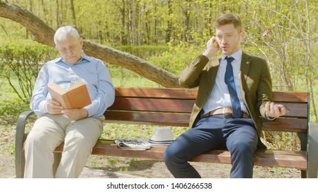 Old Man Is Reading Book In Th Park And Businessman Is Interrupting Him With Loud Conversation On Phone