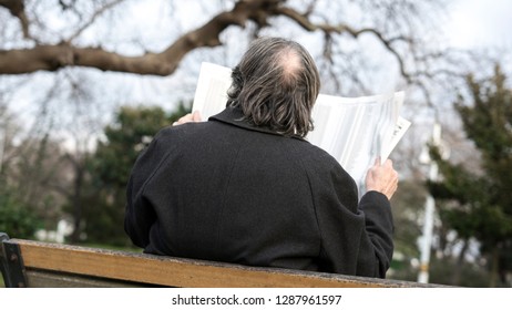 Old Man Reading Newspaper In The Park