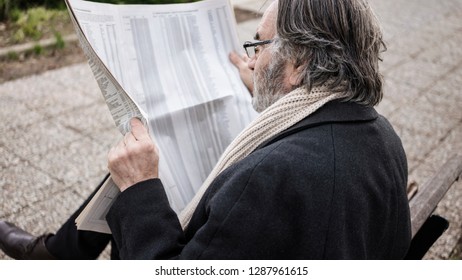 Old Man Reading Newspaper In The Park