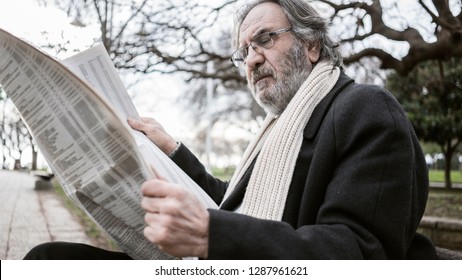 Old Man Reading Newspaper In The Park