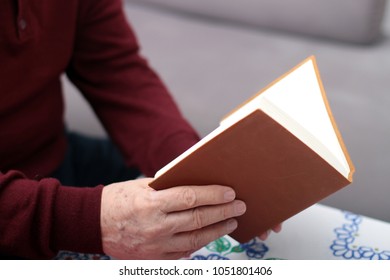 An Old Man Reading A Notebook