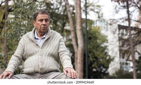 Old Man Relaxing Outdoors And Looking Away. Portrait Of Senior Man Looking Thoughtful