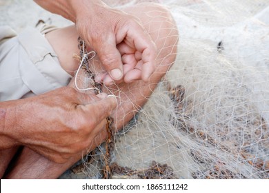 The Old Man Was Repairing The Broken Net. It Is A Device Used To Find Fish In Thailand.