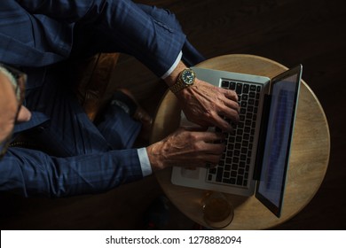 Old Man S Hands In Stylish Dark Blue Suit And Expensive Wristwatch Working On Laptop, Top View