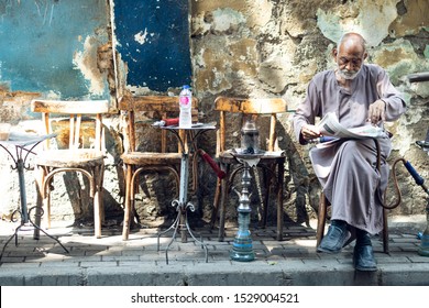 An Old Man Sitting In A Local Coffee Shop Having Tea And Shisha (hoka) In Cairo, Egypt. In September 2019