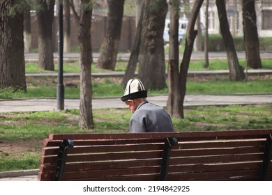 Old Man Sitting On A Bench Wearing A Traditional Kyrgyz Felt Hat