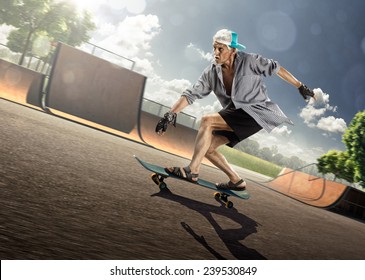 The old man is skating on skateboard in skate park
