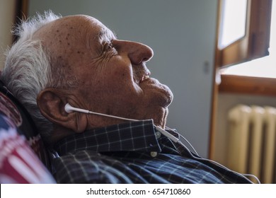 Old man sleeping listening to music with headphones