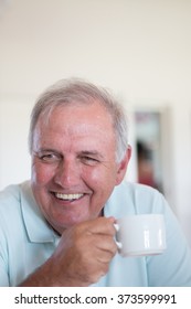 Old Man Smiling While Holding Cup Of Coffee