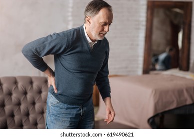 Old man standing with pain in back