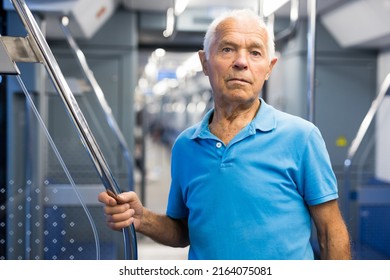 Old Man Standing In Subway Car