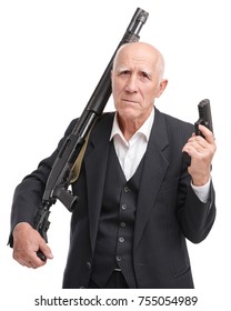 Old Man In A Suit Holds A Shotgun On His Shoulder, In The Other Hand A Gun, Isolated On A White Background