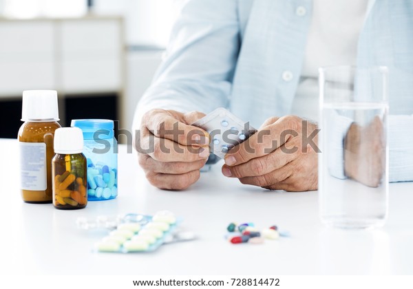 Old man taking\
pills