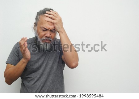 Old man touching his head because of having headache or migraine on white clean background