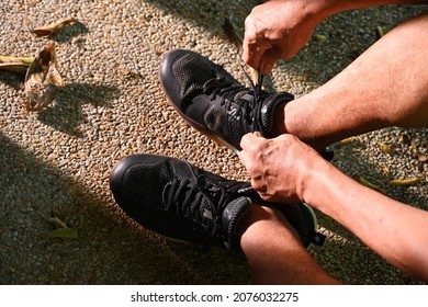 An Old Man Tying Shoes For Going Exercise