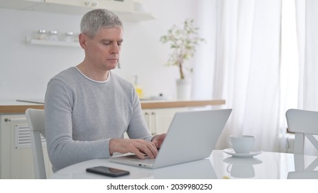 Old Man Using Laptop At Home