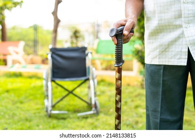 Old Man Waliking By Using Stick In Front Of Wheelchair At Hospital Garden - Concept Of Healthcare, Recovery, Treatment.