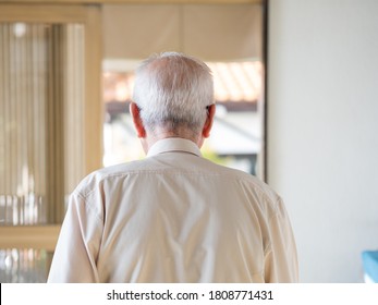 An Old Man Walking Away Into A Bright Doorway