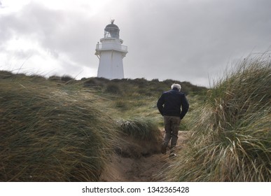 Old Man Walking To Lighthouse In New Zealand