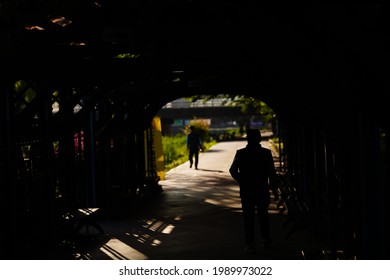 An Old Man Walking Through A Tunnel