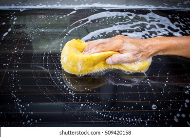 Old Man Washing Car At Home. Cleaning Car. Closeup Hand Use Yellow Sponge Washing Car. With Dark Vignette.