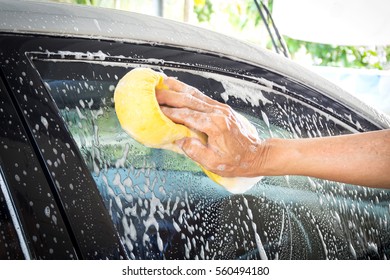 Old Man Washing Car At Home. Cleaning Car. Closeup Hand Use Yellow Sponge Washing Car.