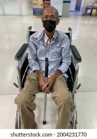 Old Man Wearing Mask To Prevent Covid Virus And Sitting On Wheelchair In Hospital, Blurry Background