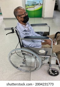 Old Man Wearing Mask To Prevent Covid Virus And Sitting On Wheelchair In Hospital, Blurry Background