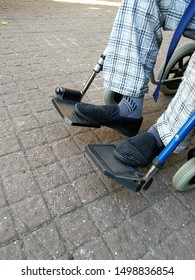 Old Man Wearing Plaid Pajamas Sitting On The Wheelchair Outside The Hospital