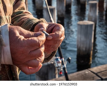 Old Man With Weathered Hands Putting Bait Onto Fishing Hook