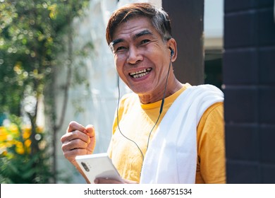 Old Man In Yellow T-shirt Standing In Front Of His House And Wave His Hand To Greeting The Neighbor.