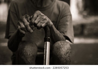 Old man's hand wearing a cane at home