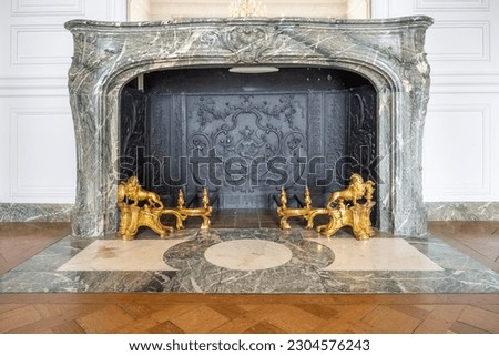Old marble fireplace with golden forging. Chateau Versailles near Paris, France