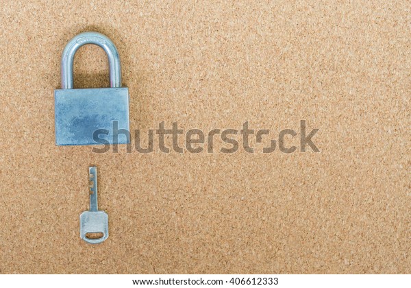 Old\
master key and key lock on cork board\
background