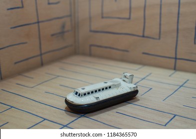 An Old Match Box Toy Car Running On A Wooden Labyrinth Pattern, Designed With A Blue Pen