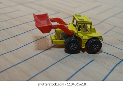 An Old Match Box Toy Car Running On A Wooden Labyrinth Pattern, Designed With A Blue Pen