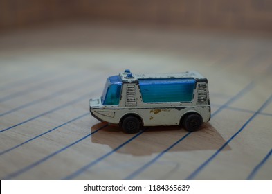 An Old Match Box Toy Car Running On A Wooden Labyrinth Pattern, Designed With A Blue Pen