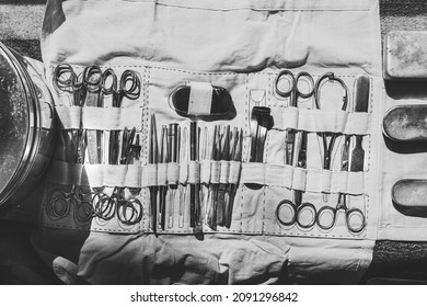 Old Medical And Surgical Instruments. Many Surgical Instruments For Surgery. Old Different Metal Medical Instruments Objects. Retro Stainless Surgical Equipment Tools. Black And White Toned Shot