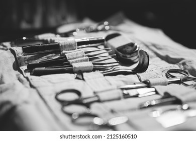 Old Medical And Surgical Instruments. Many Surgical Instruments For Surgery. Old Different Metal Medical Instruments Objects. Retro Stainless Surgical Equipment Tools. Black And White Toned Shot