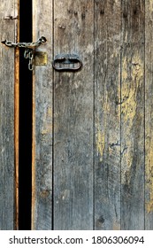 Old Medieval Door Ajar And Locked By A Chain And Padlock