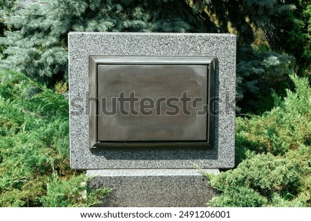 Old memorial stone with empty space for your text. Memorial stone among green foliage in the park