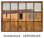 old metal barn in Nebraska Sandhills as seen from a vintage sash window