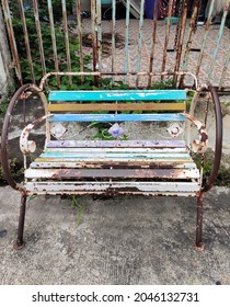 Old Metal Bench Was Placed In Front Of The Abandoned House By The Fence.