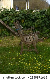 
An Old Metal Bench Stands In The Garden And Is Slowly Rusting.